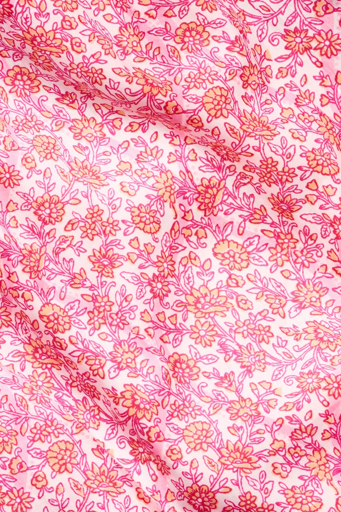 The Kids Suzie Floral Ribbon Kenia Dress by Roller Rabbit features a pink and orange floral pattern on soft, lightweight cotton sateen—an ideal choice for kids, combining delicate flowers and leaves on a light pink background.