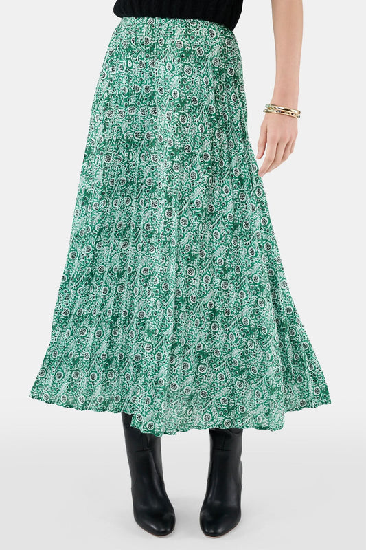 Someone wears the Roller Rabbit Fern Floral Megan Skirt—a green and white pleated maxi—paired with a black top, gold bracelets, and black heeled boots, shown from the waist down against a plain background.