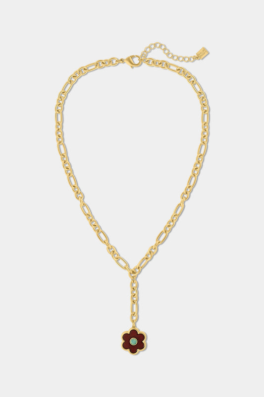 The Raya Floral Necklace by Roller Rabbit features a burgundy floral pendant with a green center on a gold chain, displayed against a white background.