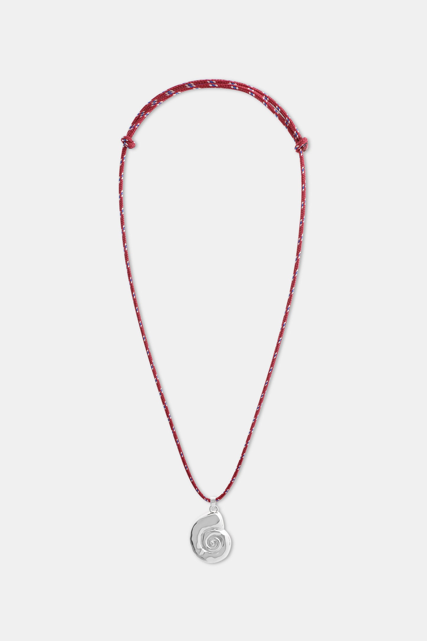 A woman wears a white shirt and the Roller Rabbit Swirl Cord Necklace—a red cord with a silver shell pendant. Only her lower face, neck, and upper chest are visible.
