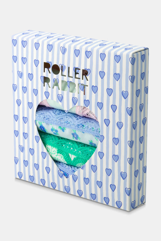 The Classic Core Bikini 4 Pack by Roller Rabbit includes four soft cotton modal panties, each with lace trim: green with hearts, light blue floral, white with blue paisley, and mint green with pink trim and embroidered hearts.
