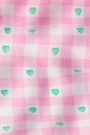 The Roller Rabbit Gingham Hearts Chrystie Bralette features pink and white striped ribbed cotton with small green hearts evenly spaced, plus a slightly wrinkled texture for added depth and gentle shadows.