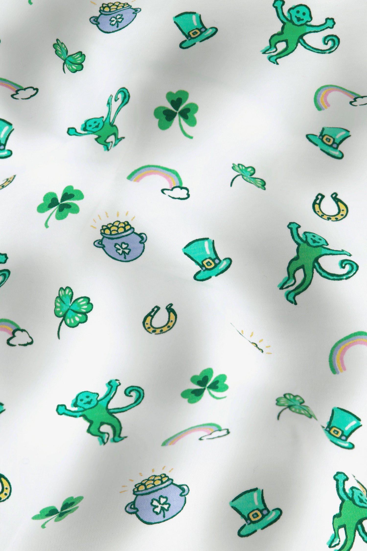 Luck O' the Monkey Polo Pajamas feature a playful St. Patrick’s Day print with green monkeys, shamrocks, leprechaun hats, and rainbows on white—perfect for celebrating in style.