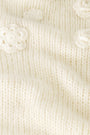 A close-up of the Crochet Floral Quinn Sweater’s soft, cream knit showcases raised crochet floral details and textured stitches, giving it a cozy, delicate look.