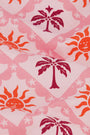 The Kids Sunny Days Rashguard by Roller Rabbit is a pink long-sleeve rashguard with a quarter-zip front, decorated with orange suns and red palm trees on a light pink background for playful sun protection.