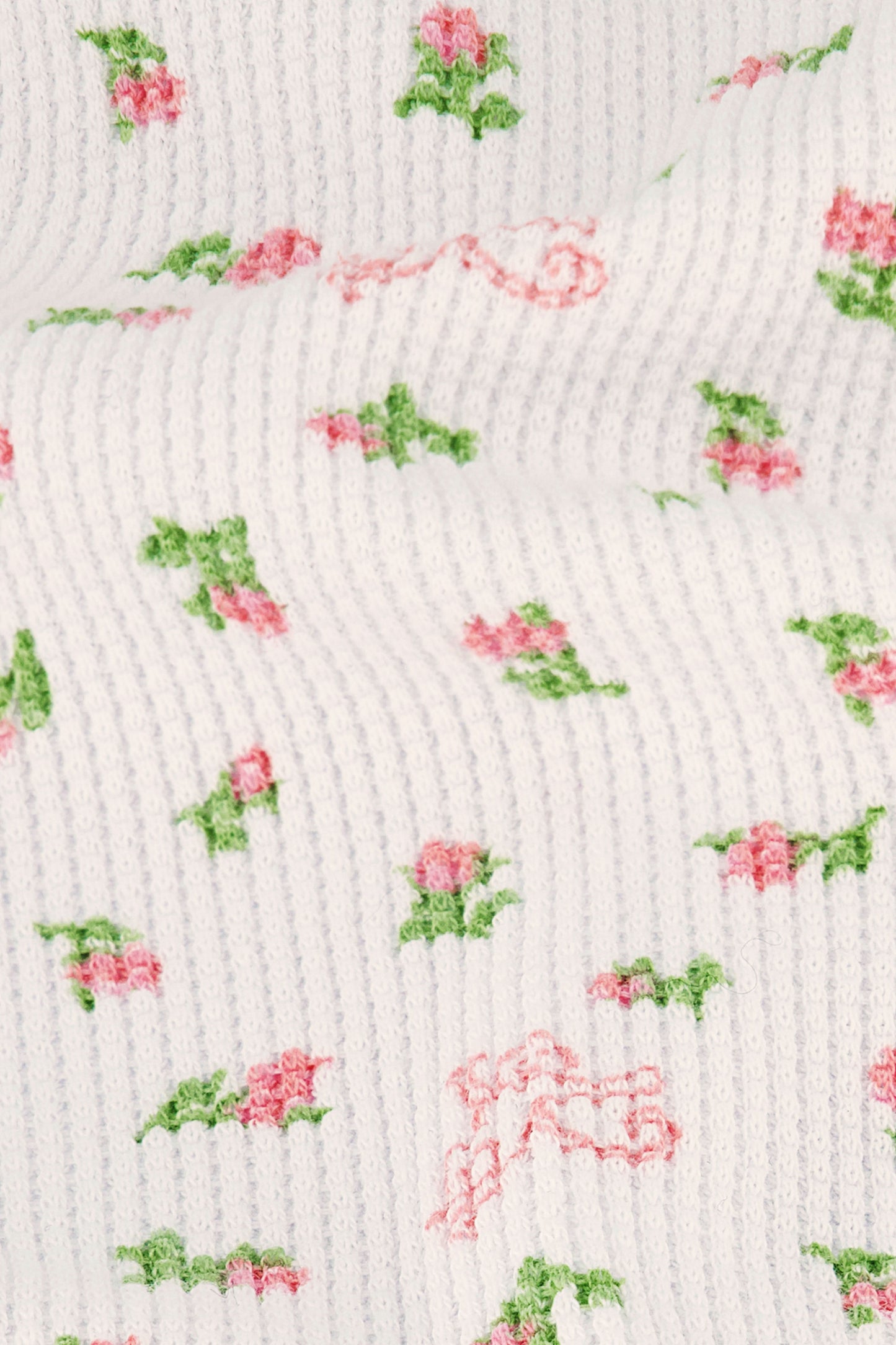 A woman stands barefoot against a white background, wearing the Roller Rabbit Mini Monkey Blossom Cherry Tank Set—a matching white tank top and shorts with a small floral pattern.