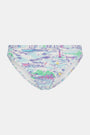 A person wears the Roller Rabbit Regatta Marais Bikini Bottom, featuring a colorful nautical print with boats and lighthouses. The UPF 50+ swimwear offers sun protection. Image is cropped from chest to upper thighs.