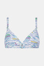 A woman with long brown hair smiles softly, wearing the Regatta Marais Bikini Top by Roller Rabbit in a nautical print, standing against a plain white background.