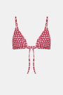 A woman wears the Roller Rabbit Starry Dot Isa Bikini Top, a red triangle bikini with white polka dots and a front tie, shown from shoulders to waist against a plain background.