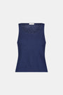 A woman wears the Roller Rabbit Pointelle Sasha Sweater Tank in navy with a textured open-weave design, paired with white shorts featuring blue floral prints. She is shown from shoulders to waist, looking slightly to the side.