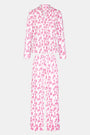 The Roller Rabbit Gigi Giraffe Long Sleeve Polo Pajamas feature a matching set with long sleeves and pants, showcasing an all-over pink giraffe print on a white background.