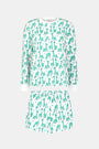 The Gigi Giraffe Hunter Pajamas by Roller Rabbit is a women’s Pima Cotton set with a white base and green-blue giraffe print, featuring a long sleeve top and elastic-waist shorts, shown on a plain light gray background.