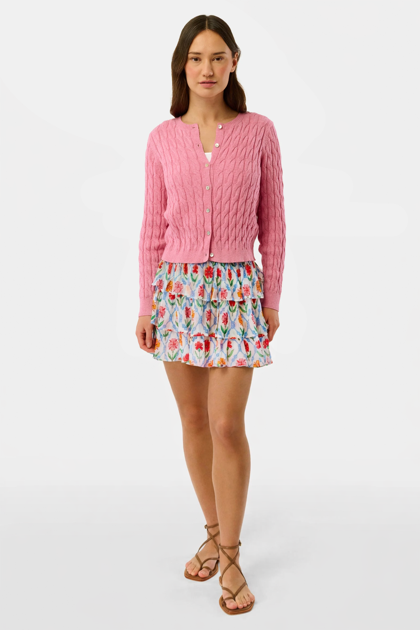 A close-up of the Roller Rabbit Infinity Floral Siggy Skirt, a crinkle chiffon mini with ruffles, featuring red, yellow, pink, and green florals on white. The skirt is styled with a white top.