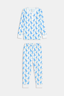 A young child with curly hair stands barefoot in white Kids Romy Rabbit Pajamas by Roller Rabbit, featuring a blue bunny print, looking at the camera and touching their mouth with one finger.