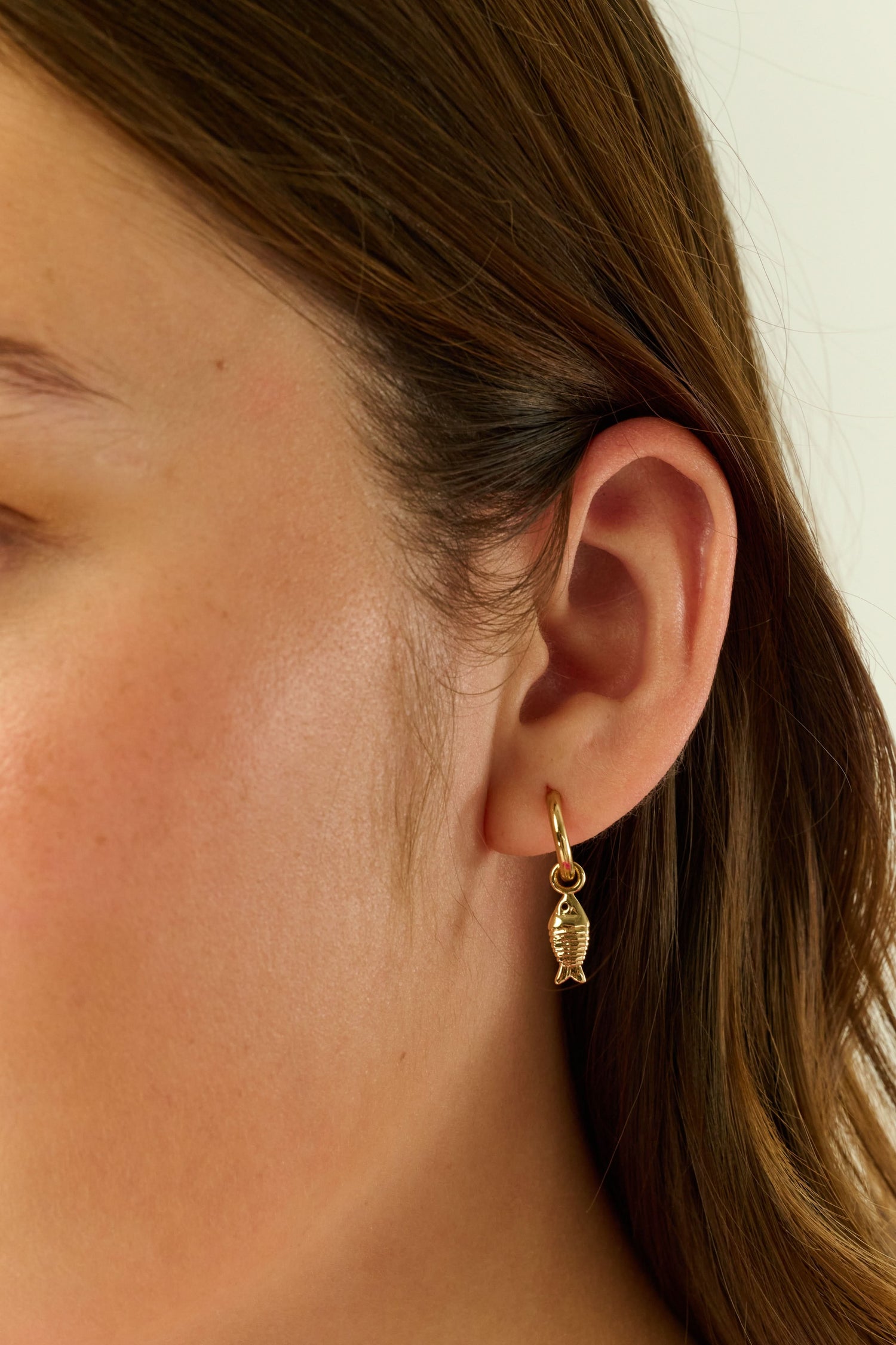 The Marina Earrings Set by Roller Rabbit includes four gold hoops: two with removable oval white shell charms and two with gold fish-shaped charms, all shown on a light gray background.