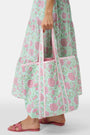 The Roller Rabbit Camellia Block Quilted Tote features pink and green floral patterns, a pale pink interior lining, and long white handles, shown on a plain white background.