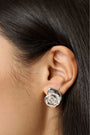 Roller Rabbit Swirl Stud Earrings: shiny silver studs shaped like abstract shells with a raised spiral design in the center, shown on a plain light gray background.