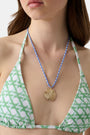 The Roller Rabbit Seashell Cord Necklace features a blue and white braided adjustable cord with a gold shell pendant, shown on a plain white background.