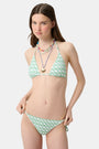 A young woman models the Roller Rabbit Cane Serena Bikini Top, featuring a green cane print triangle style, shown from the shoulders up against a plain background.