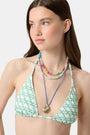 A young woman models the Roller Rabbit Cane Serena Bikini Top, featuring a green cane print triangle style, shown from the shoulders up against a plain background.