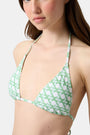 A young woman models the Roller Rabbit Cane Serena Bikini Top, featuring a green cane print triangle style, shown from the shoulders up against a plain background.