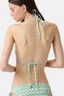 A young woman models the Roller Rabbit Cane Serena Bikini Top, featuring a green cane print triangle style, shown from the shoulders up against a plain background.
