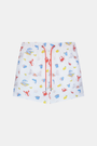 A person stands barefoot, one hand in a pocket, wearing a white T-shirt and Roller Rabbit Men's Catch of the Day Swim Trunk with colorful beach-themed prints, an elastic waistband, and a classic fit.