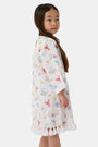 A young child with light brown hair smiles near an open car door, wearing the Roller Rabbit Kids Catch of the Day Serafina Tunic. An adult in matching pajamas is partially visible behind them.
