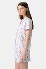 A woman stands barefoot in Roller Rabbit's Catch of the Day Polo Pajamas—short-sleeve, button-up PJs with matching shorts, both featuring a colorful seaside print—facing forward against a plain white background.