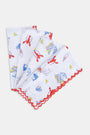 The Catch of the Day Napkin Set Of 4 by Roller Rabbit features white linen napkins with red scalloped edges, showcasing playful sea, beach, and ice cream prints in blue, red, and yellow. The napkins are arranged slightly overlapping.