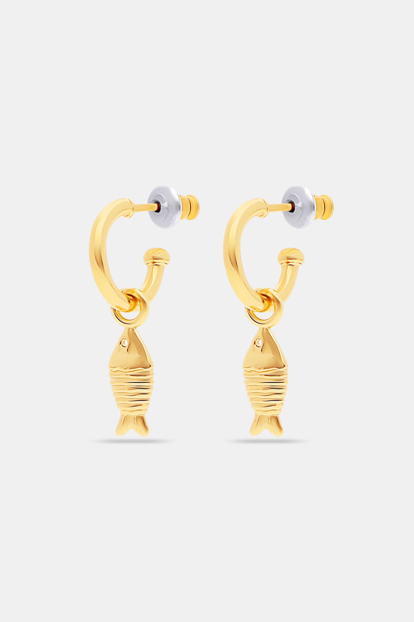 The Marina Earrings Set by Roller Rabbit includes four gold hoops: two with removable oval white shell charms and two with gold fish-shaped charms, all shown on a light gray background.
