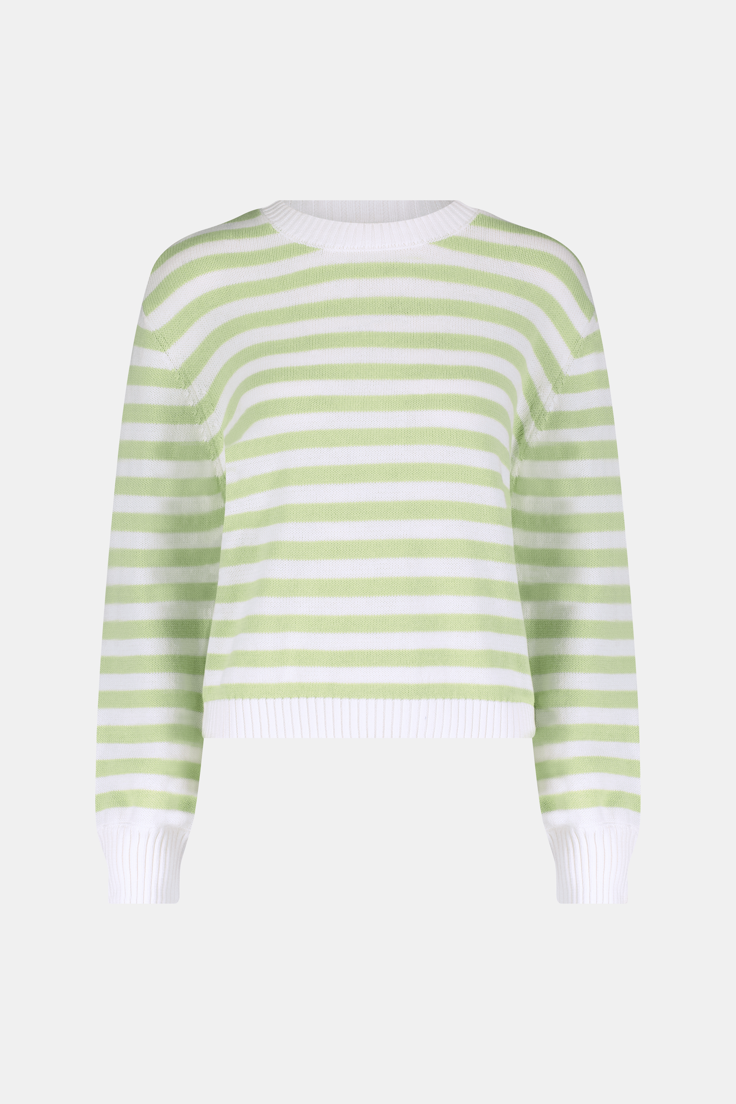 A woman with straight brown hair wears the Roller Rabbit Striped Hadley Sweater in sage green and white stripes, paired with white high-waisted pants and a beaded necklace, standing against a plain background and looking at the camera.