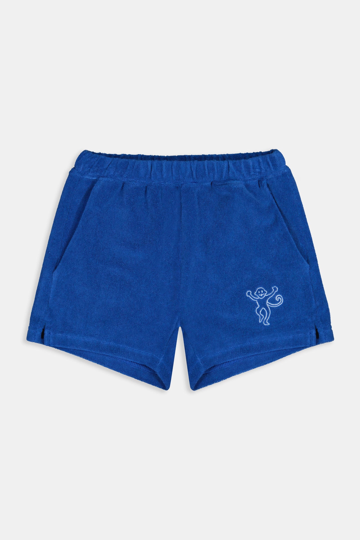 A child wears Roller Rabbit’s Kids Monkey Embroidery Hanni Short in navy with an embroidered figure on the left leg, matching blue top, and white velcro sneakers. Perfect summer shorts for active days.