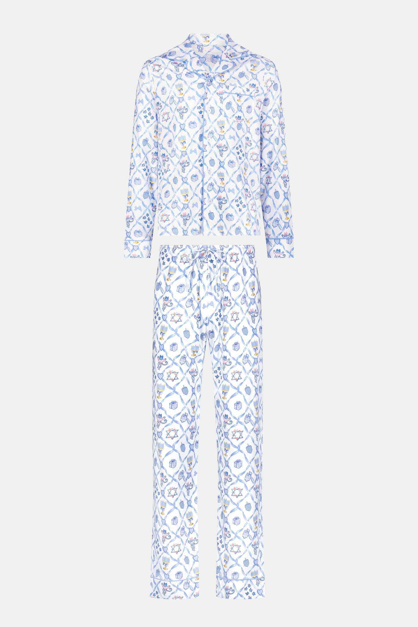 A man stands barefoot on a white background wearing Roller Rabbit's Mens Starry Nights Lattice Long Sleeve Polo Pajamas, featuring light blue and white patterns. He smiles with one hand in his pocket, highlighting the comfort of these matching PJs.