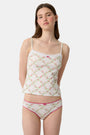 A person wearing the Roller Rabbit Raspberry Garden Gwen Bikini, a matching white camisole and vintage-inspired underwear set with a pink floral pattern and pink trim, shown from mid-torso to upper thighs.