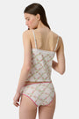 A person wearing the Roller Rabbit Raspberry Garden Gwen Bikini, a matching white camisole and vintage-inspired underwear set with a pink floral pattern and pink trim, shown from mid-torso to upper thighs.