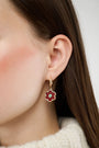 The Roller Rabbit Raya Floral Earring features gold huggie hoops with burgundy florals, turquoise centers, and red flower-shaped charms—an elegant Autumn accessory, shown against a white background.