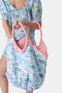 The Regatta Bondi Bag by Roller Rabbit is a large cotton canvas tote with pink and white striped handles, showcasing a vibrant nautical print of boats, lighthouses, and coastal scenery on a white background.