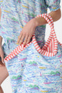 The Regatta Bondi Bag by Roller Rabbit is a large cotton canvas tote with pink and white striped handles, showcasing a vibrant nautical print of boats, lighthouses, and coastal scenery on a white background.