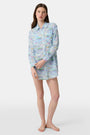 A woman wears the Roller Rabbit Regatta Boyfriend Dress, a loose-fitting cotton voile piece with long sleeves and colorful pastel abstract patterns. The thigh-length dress features a relaxed fit as she stands against a plain, light background.
