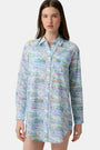 A woman wears the Roller Rabbit Regatta Boyfriend Dress, a loose-fitting cotton voile piece with long sleeves and colorful pastel abstract patterns. The thigh-length dress features a relaxed fit as she stands against a plain, light background.