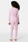 A young girl smiles barefoot in Roller Rabbit’s Kids Romy the Rabbit Pajamas, a soft Pima cotton long-sleeve set with a playful rabbit print; her brown hair frames her face against a simple, light background.