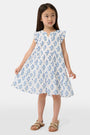 A young girl with long brown hair wears the Roller Rabbit Kids Rosa Ditsy Floral Pami Dress, made from cotton voile with blue-green block print and ruffled sleeves, standing against a plain light background, looking slightly to the side.