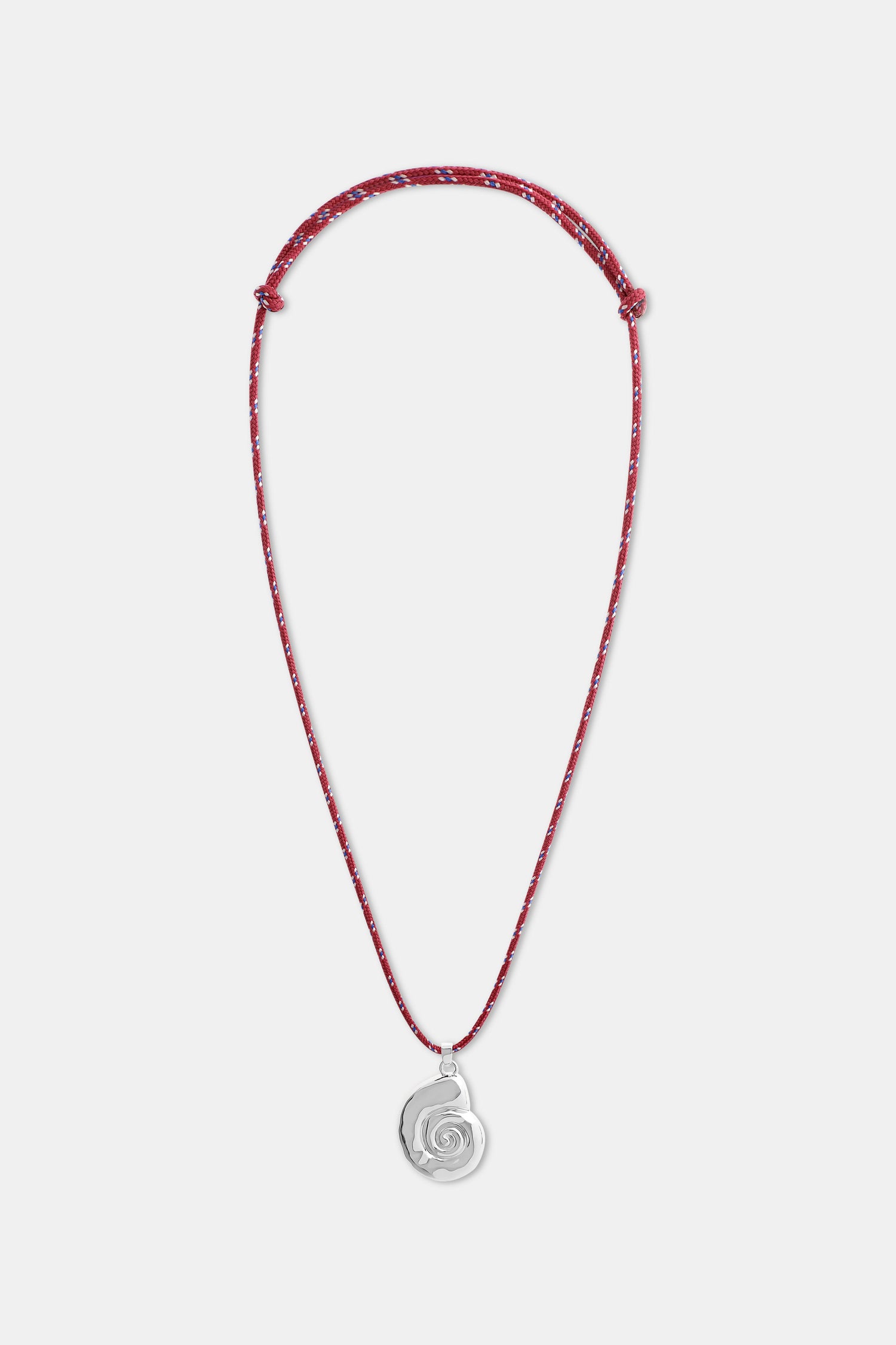 A woman wears a white shirt and the Roller Rabbit Swirl Cord Necklace—a red cord with a silver shell pendant. Only her lower face, neck, and upper chest are visible.