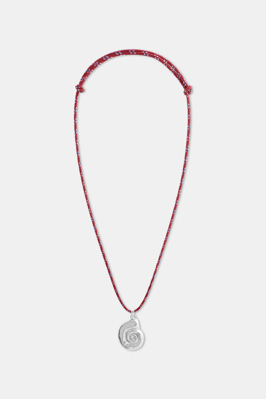 A woman wears a white shirt and the Roller Rabbit Swirl Cord Necklace—a red cord with a silver shell pendant. Only her lower face, neck, and upper chest are visible.
