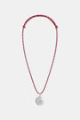 A woman wears a white shirt and the Roller Rabbit Swirl Cord Necklace—a red cord with a silver shell pendant. Only her lower face, neck, and upper chest are visible.
