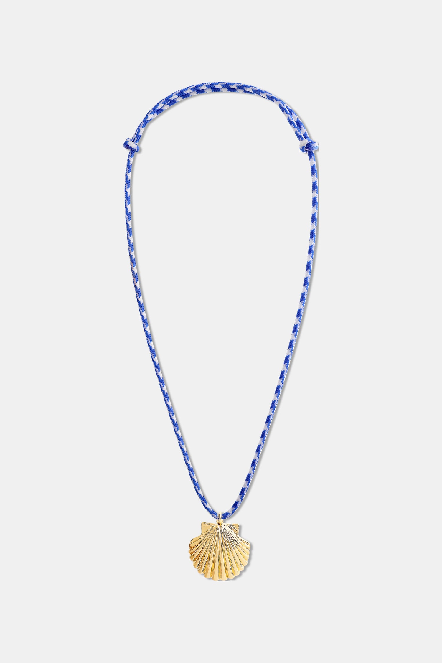 The Roller Rabbit Seashell Cord Necklace features a blue and white braided adjustable cord with a gold shell pendant, shown on a plain white background.