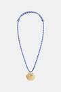 The Roller Rabbit Seashell Cord Necklace features a blue and white braided adjustable cord with a gold shell pendant, shown on a plain white background.