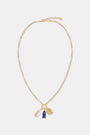 Roller Rabbit's Coastal Charm Necklace features a gold-tone chain with a white shell, blue fish, and gold spiral shell pendant—perfect for summer style—shown on a plain white background.