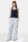 A woman wears the Roller Rabbit Pointelle Sasha Sweater Tank in navy with a textured open-weave design, paired with white shorts featuring blue floral prints. She is shown from shoulders to waist, looking slightly to the side.
